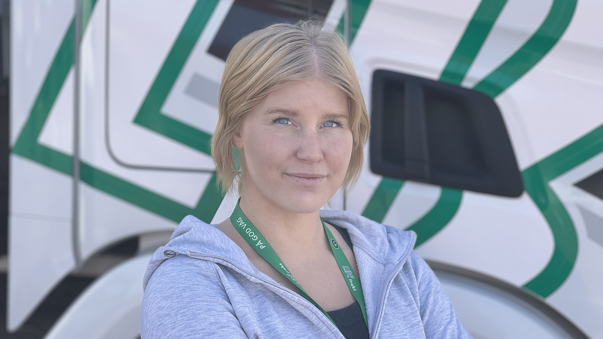 Porträttfoto av Madeleine Jonsson som står vid hytten på en lastbil -LBC Frakt.